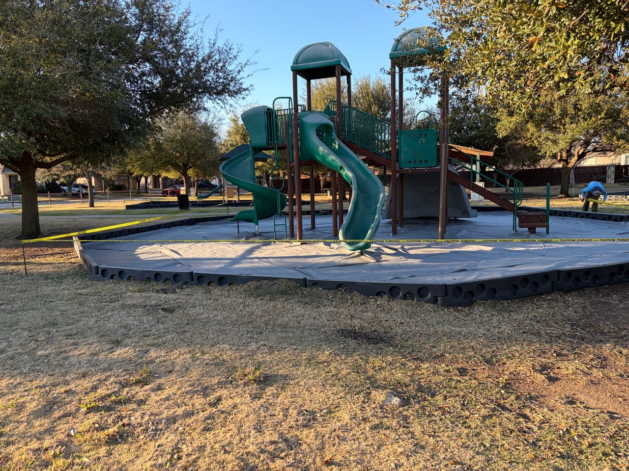 Park playground with stripped mulch bed ready for new material in Central Texas