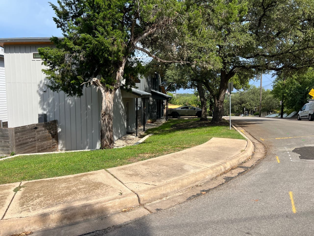 Tree lined sidewalk and maintained lawn along a quiet street in Central Texas