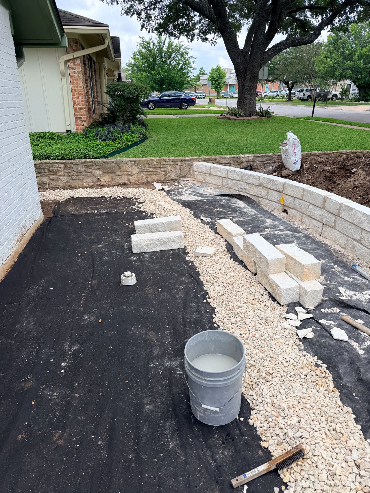 Curved limestone retaining wall and gravel bed in Austin, TX