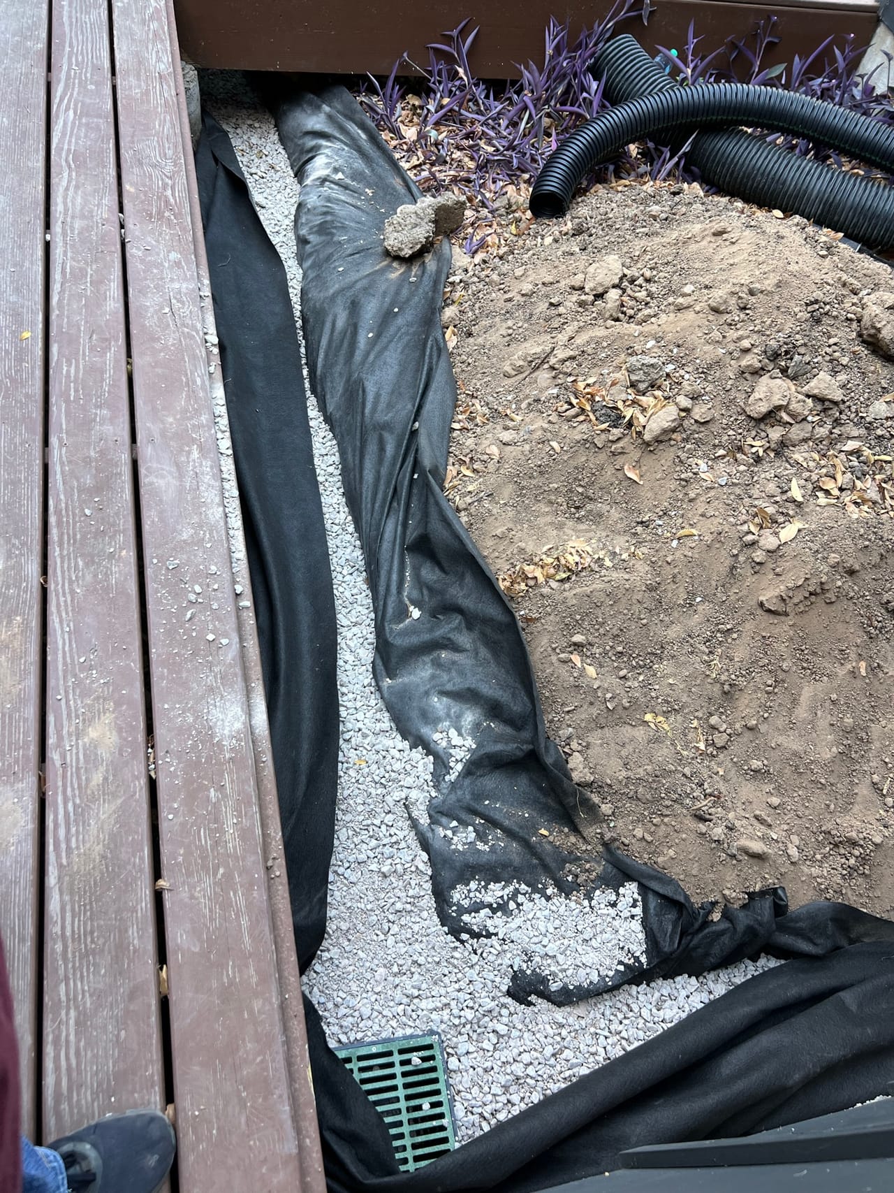 French drain close up with corrugated pipe, filter fabric and gravel in Kyle, TX