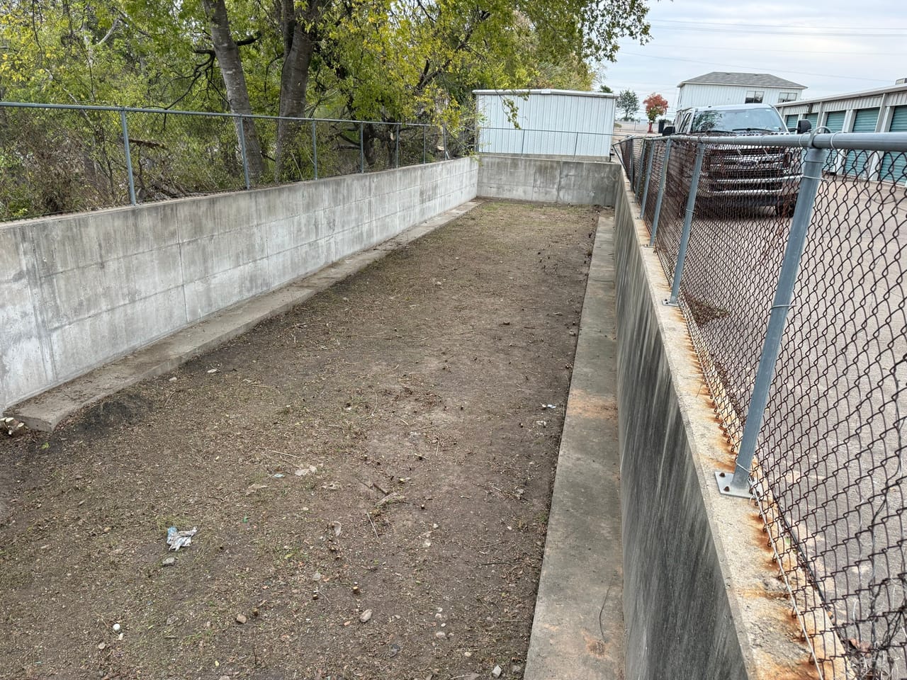 Wide clean concrete drainage channel after full vegetation and silt removal in Leander, TX