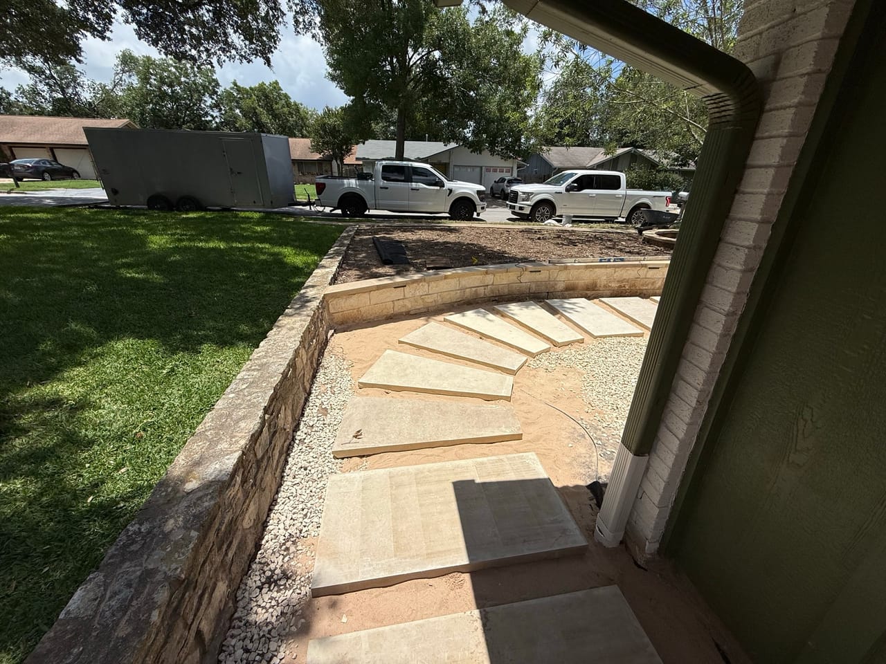 Curved flagstone landing with stone border at a house corner in Central Texas