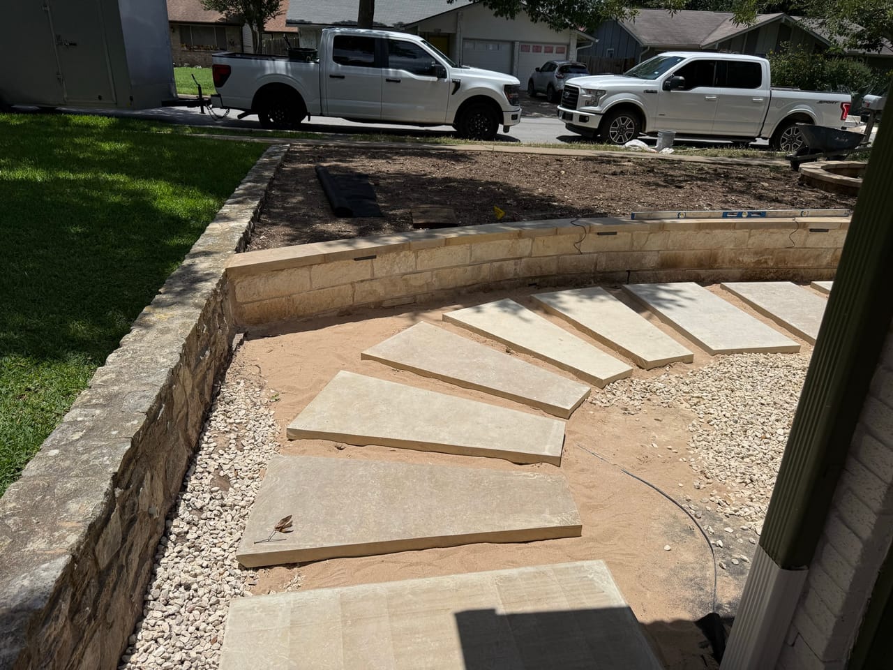 Curved flagstone walkway edged with gravel and a stone retaining border in Central Texas
