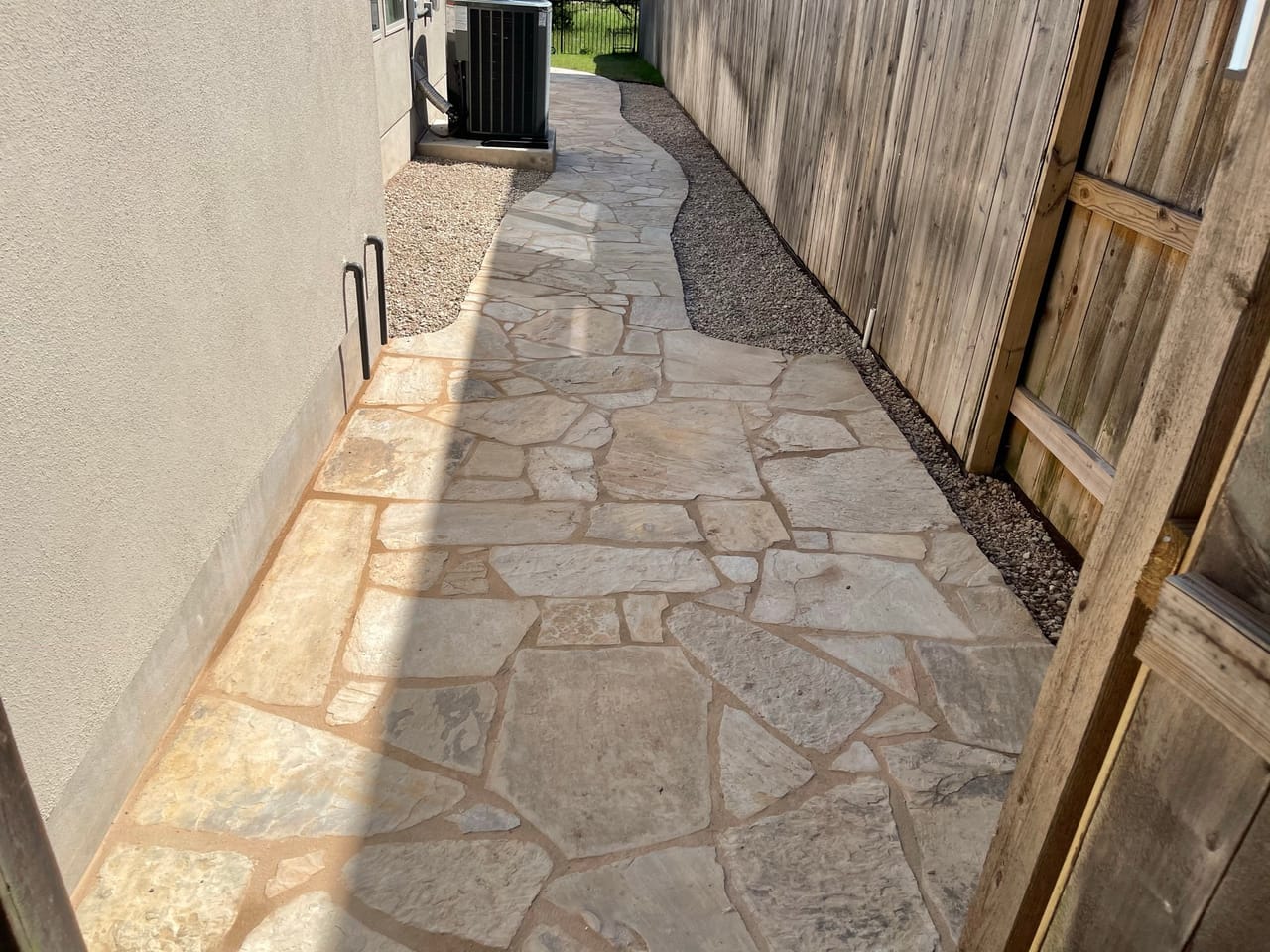 Finished flagstone side yard path running along a wood fence in Round Rock, TX