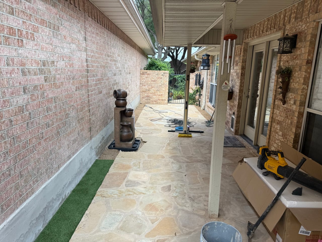 Finished flagstone walkway with turf edging along a brick house in Central Texas