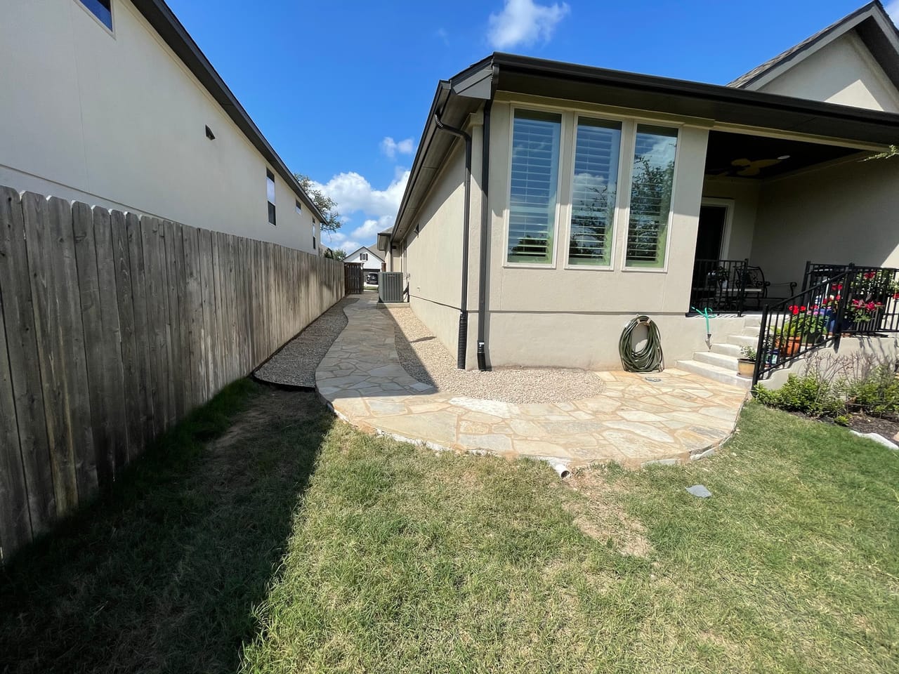 Finished side yard flagstone path with lawn and fence by Corral Bros in Central Texas