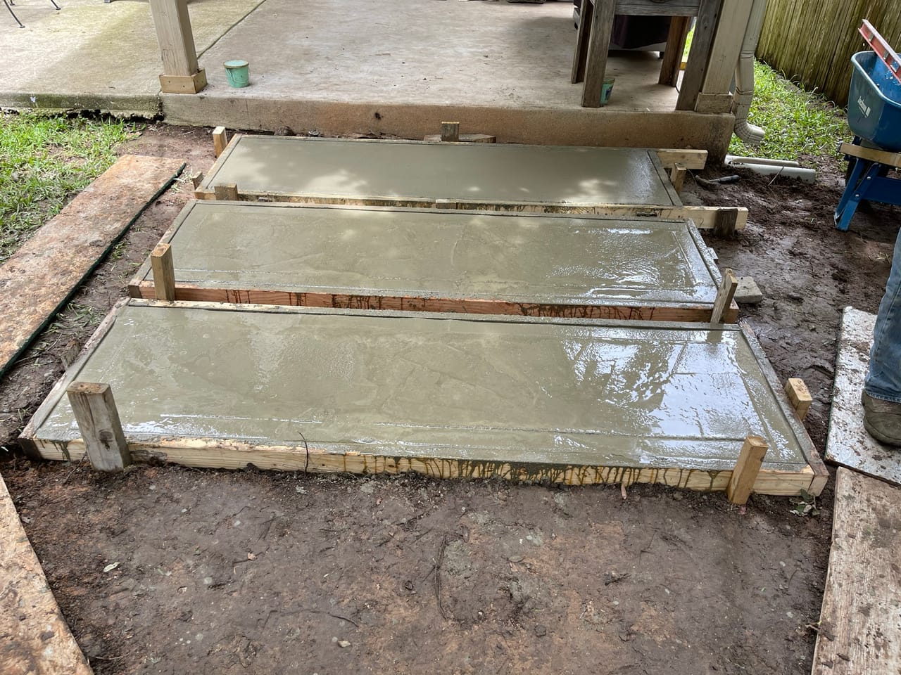 Freshly poured concrete slabs curing inside wood forms by Corral Bros in Central Texas