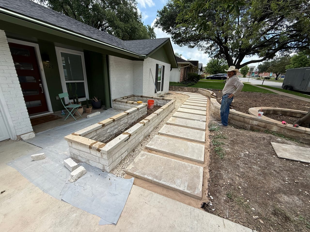 New flagstone walkway and limestone raised bed across a house front in Central Texas