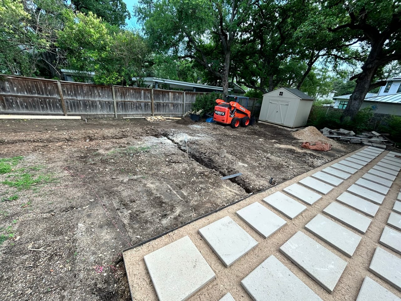 Paver walkway laid across a dirt yard with skid steer behind by Corral Bros in Central Texas