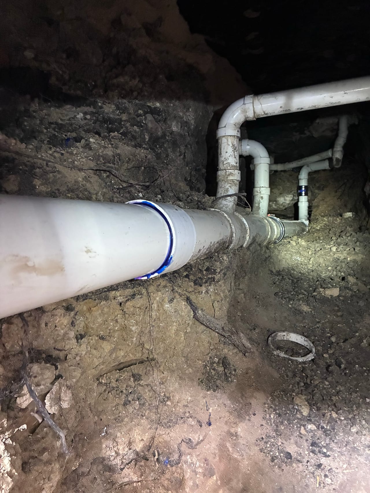 Fresh PVC pipe run with fittings set in a rock trench in Leander, TX