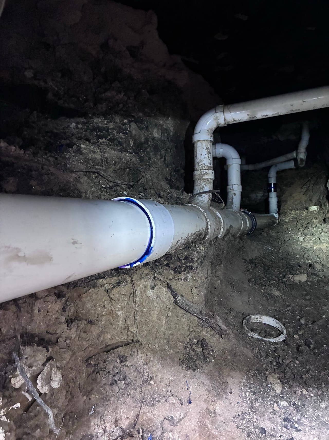 New PVC line with elbows and fittings assembled in a trench in Central Texas