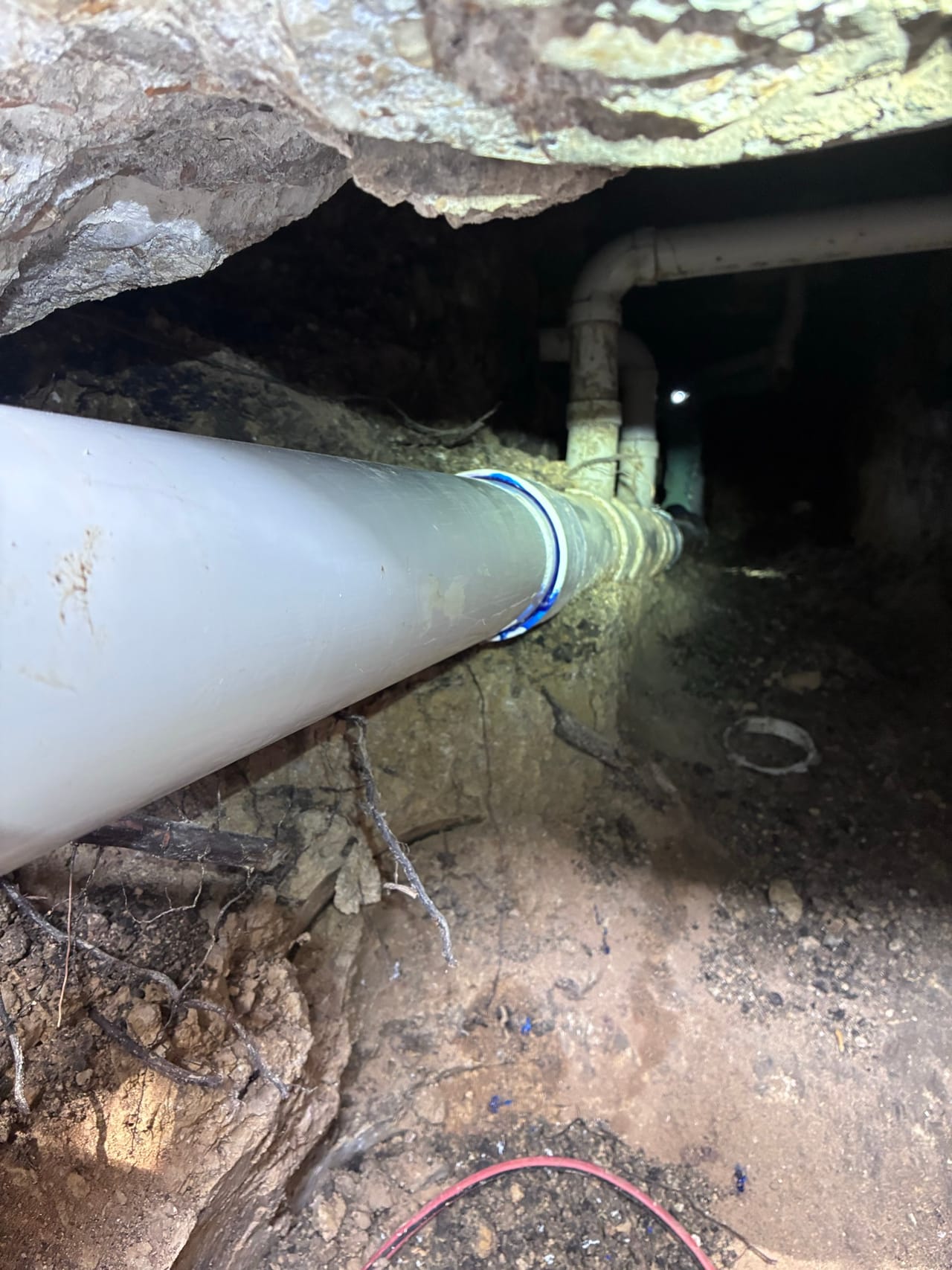New white PVC line coupled into an existing pipe in a trench in Pflugerville, TX