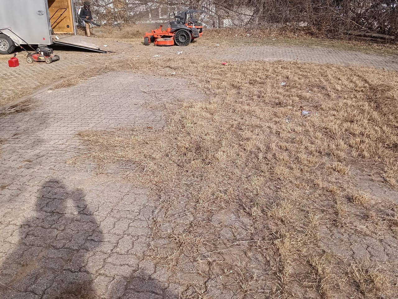 Scraped dirt lot with a red zero turn mower parked at the edge in Buda, TX