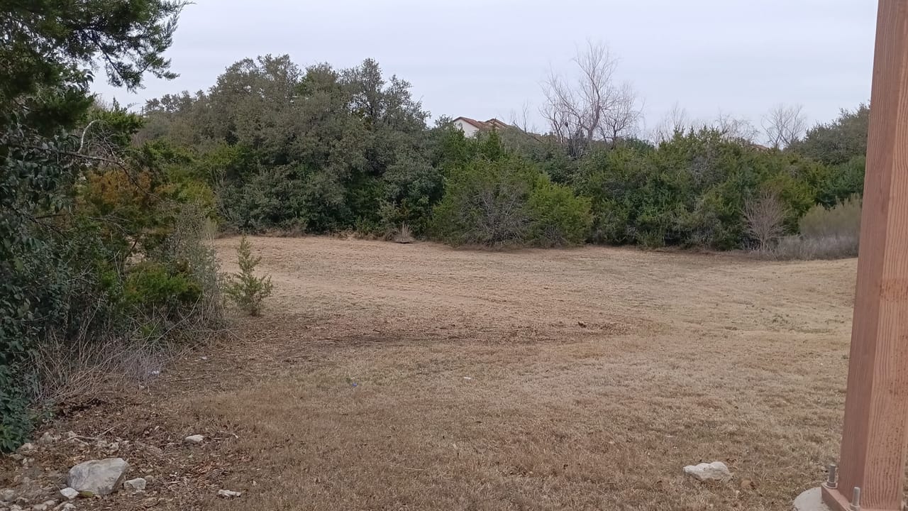 Wide cleared field of dry grass with trees along the back line in Maxwell, TX