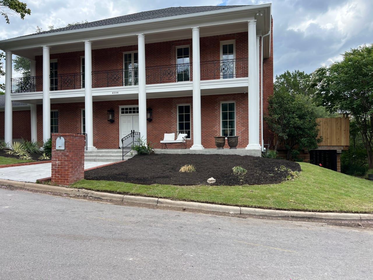 Two story brick colonial with fresh mulch beds and clean lawn in Georgetown, TX