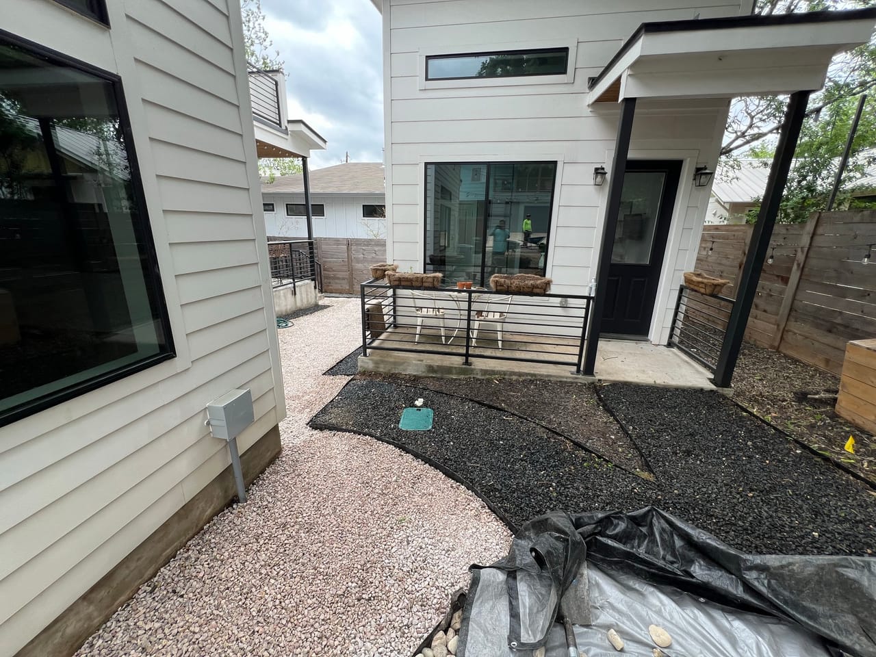 Courtyard gravel install underway with fabric still on the ground by Corral Bros in Central Texas