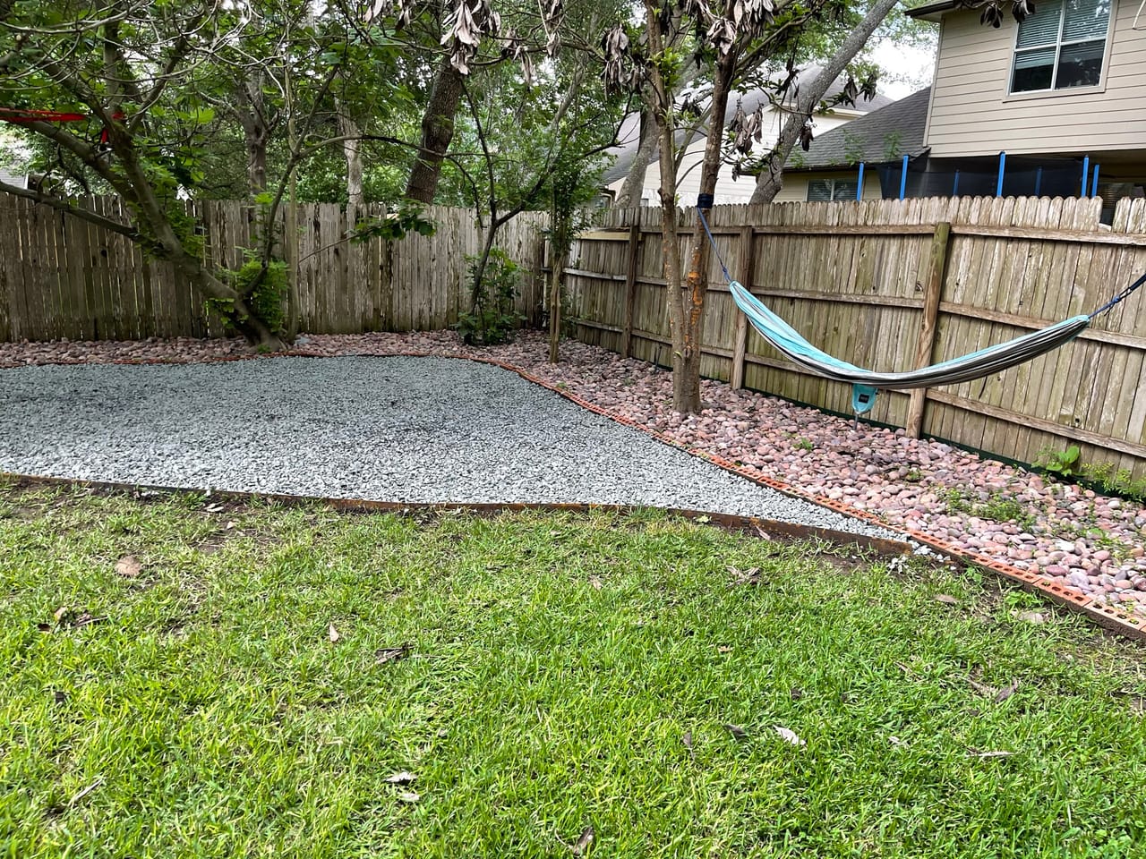 Finished backyard gravel patio area with wood fence and hammock in Leander, TX