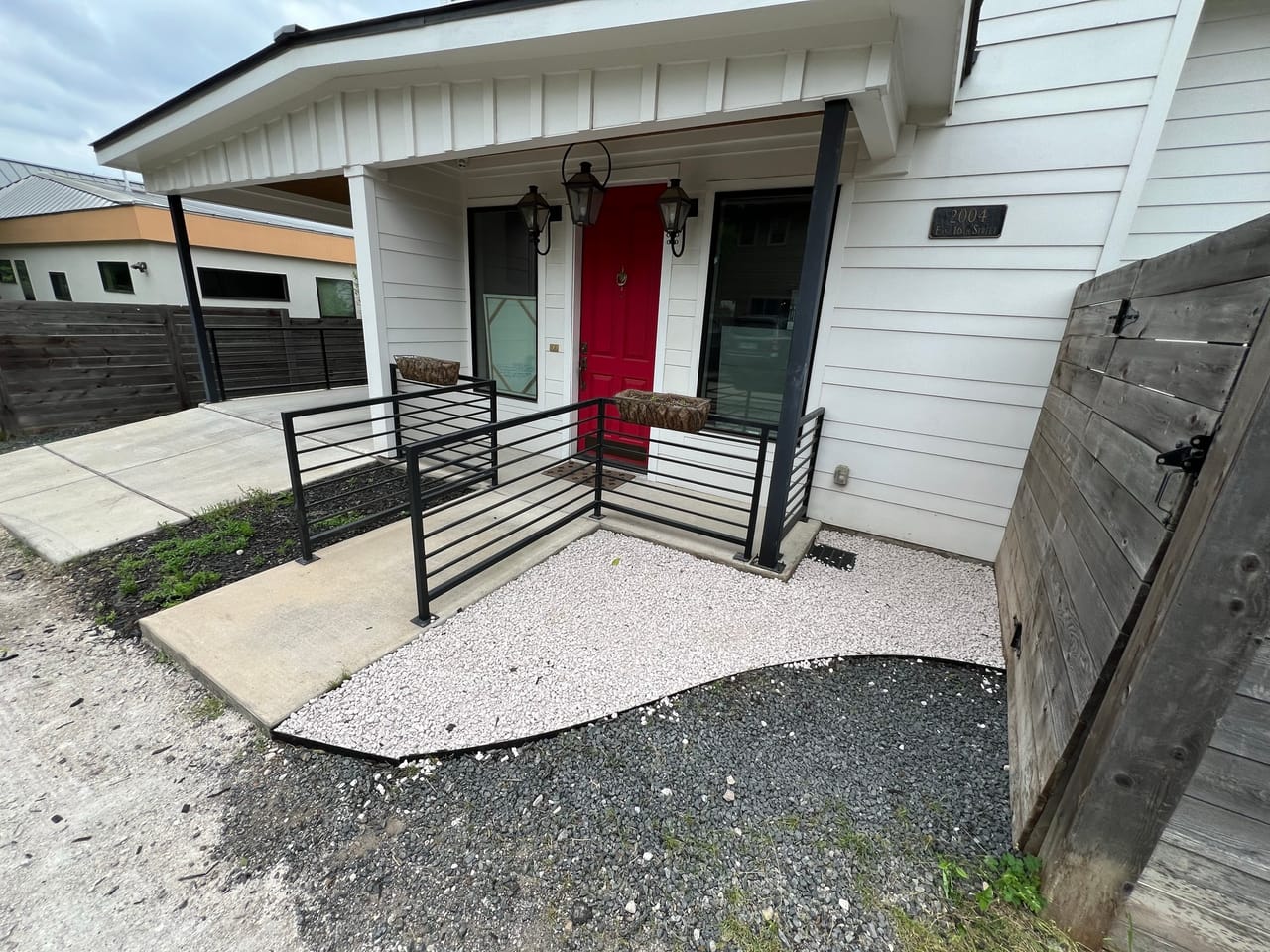 Finished entry with white gravel and curved black rock border in Buda, TX