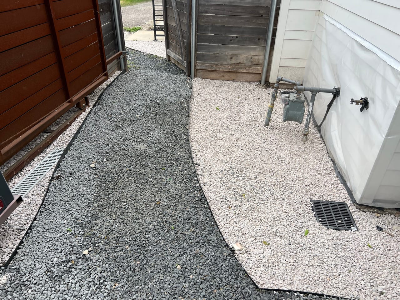 Finished gravel path curving between a fence and house siding in Georgetown, TX
