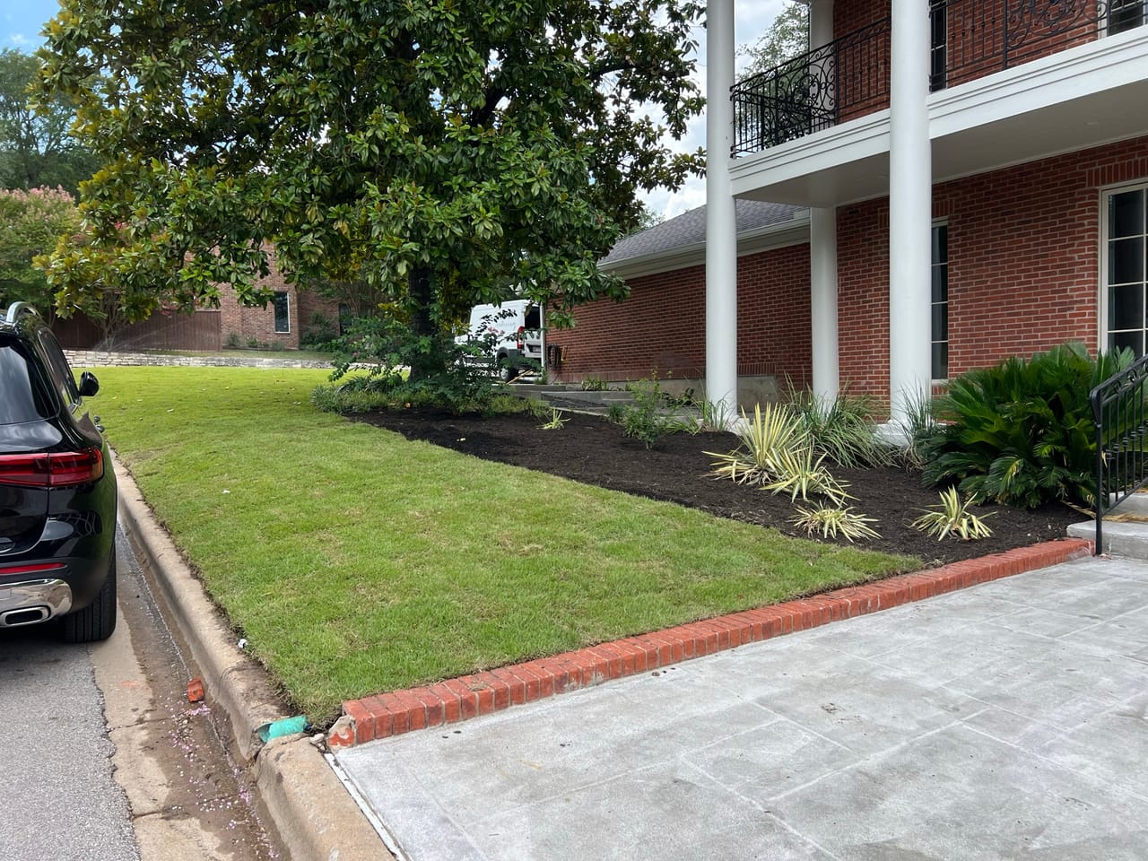 Front lawn and new mulch beds with an SUV at the curb in Leander, TX