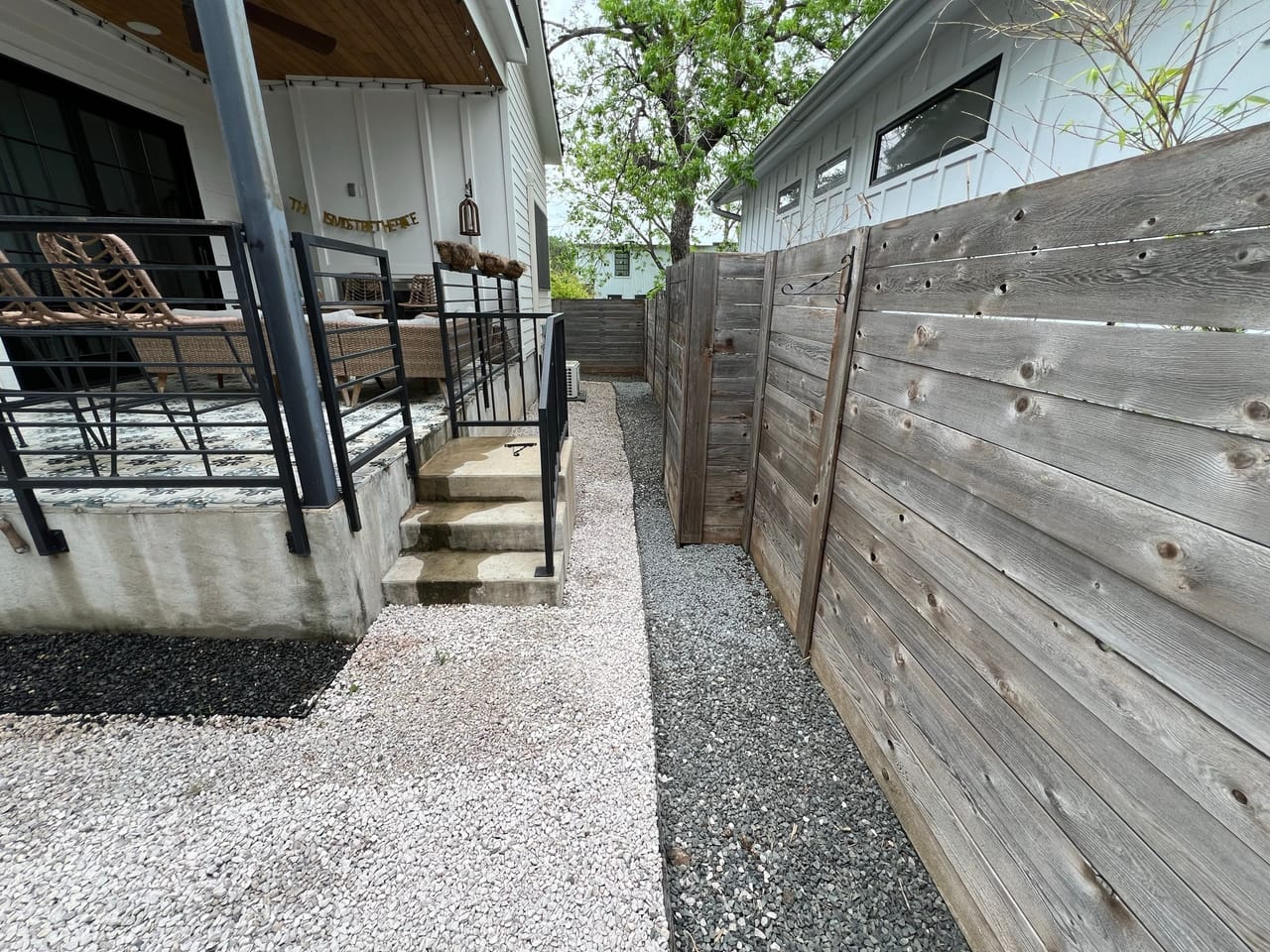 Gravel walkway running past porch steps along a privacy fence by Corral Bros in Central Texas