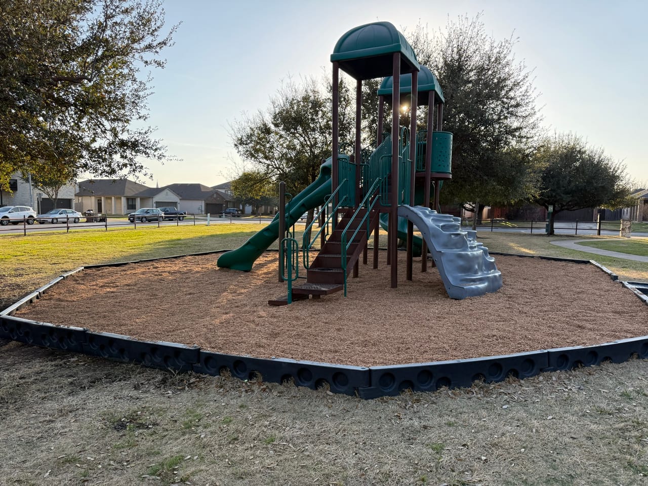 Playground with freshly spread mulch and clean black border edging in Central Texas