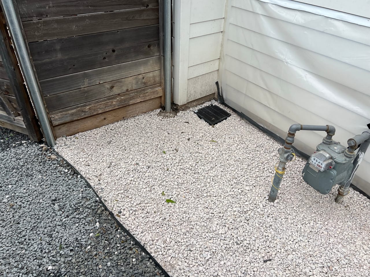 White gravel yard with black rock border and gas meter by Corral Bros in Central Texas