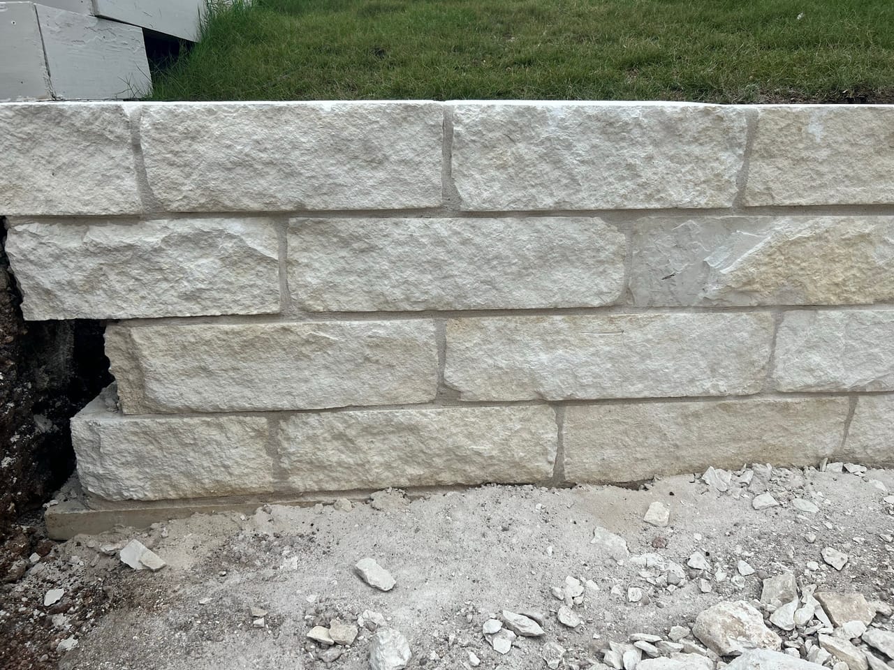 Close view of a finished limestone block retaining wall on gravel base in West Lake Hills, TX