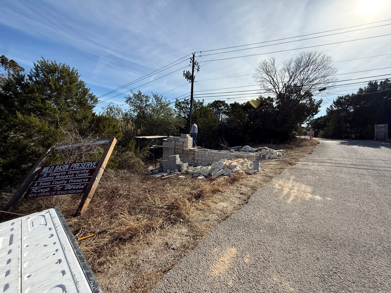 Distant view of stone entrance wall work along a roadway by Corral Bros in Central Texas