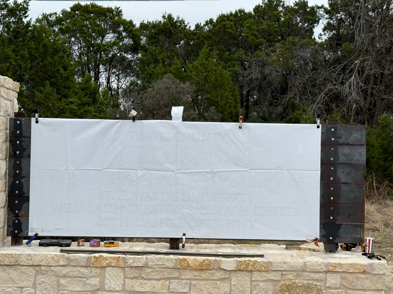Finished limestone entrance monument with large white sign face in Round Rock, TX