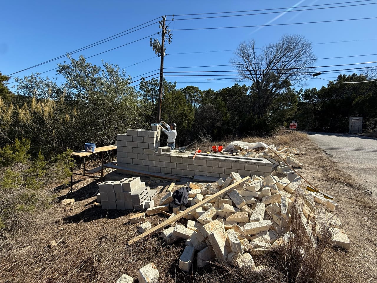 Wide view of block wall build beside a country road by Corral Bros in Central Texas