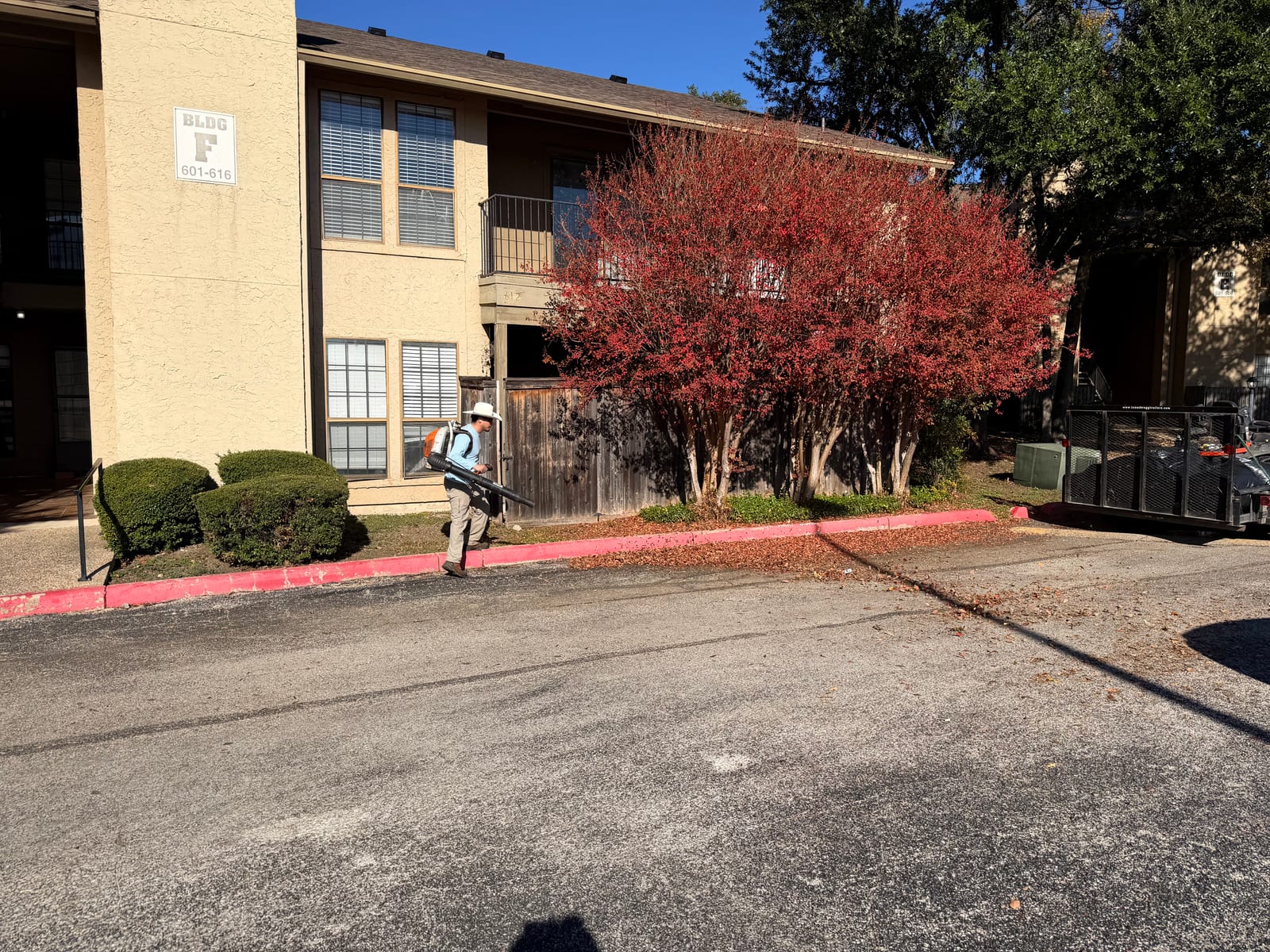 Corral Bros crew doing seasonal leaf cleanup at an apartment property in Austin, TX