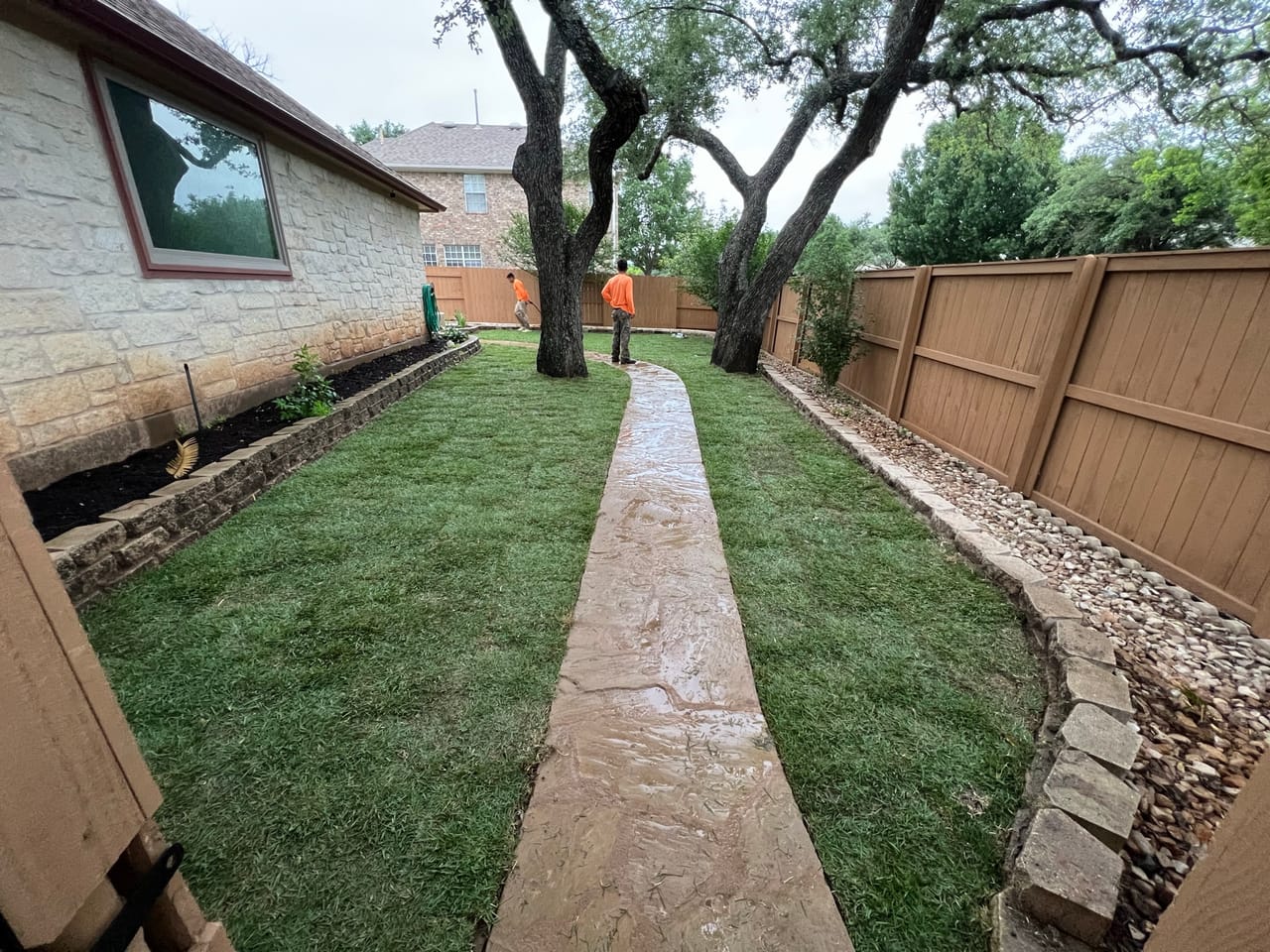 Fresh sod lawn flanking a flagstone path between fence and house in Round Rock, TX