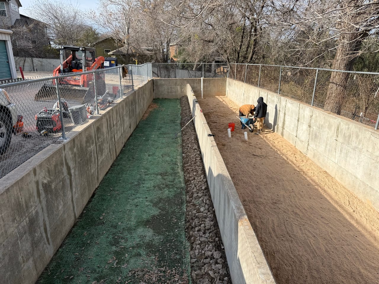 Channel with green matting on one slope and hydromulch on the other in Taylor, TX