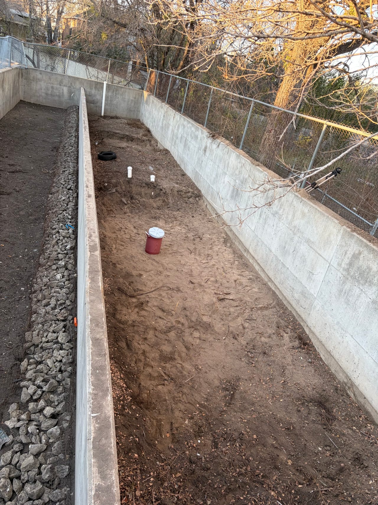 Concrete channel with cobble riprap toe and freshly dressed dirt slope in Lago Vista, TX