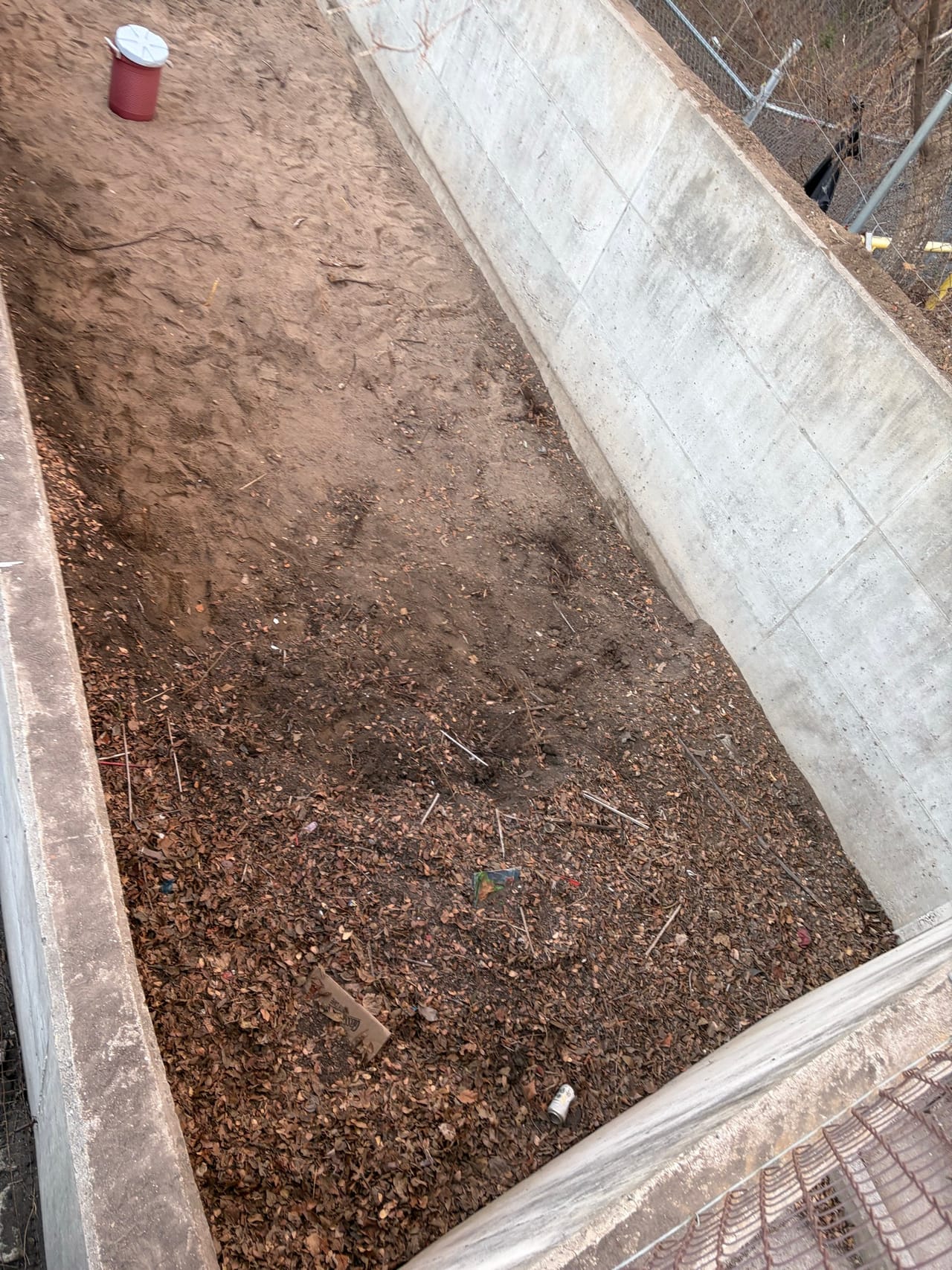 Concrete lined drainage channel with mulch spread over the bare soil slope in Round Rock, TX
