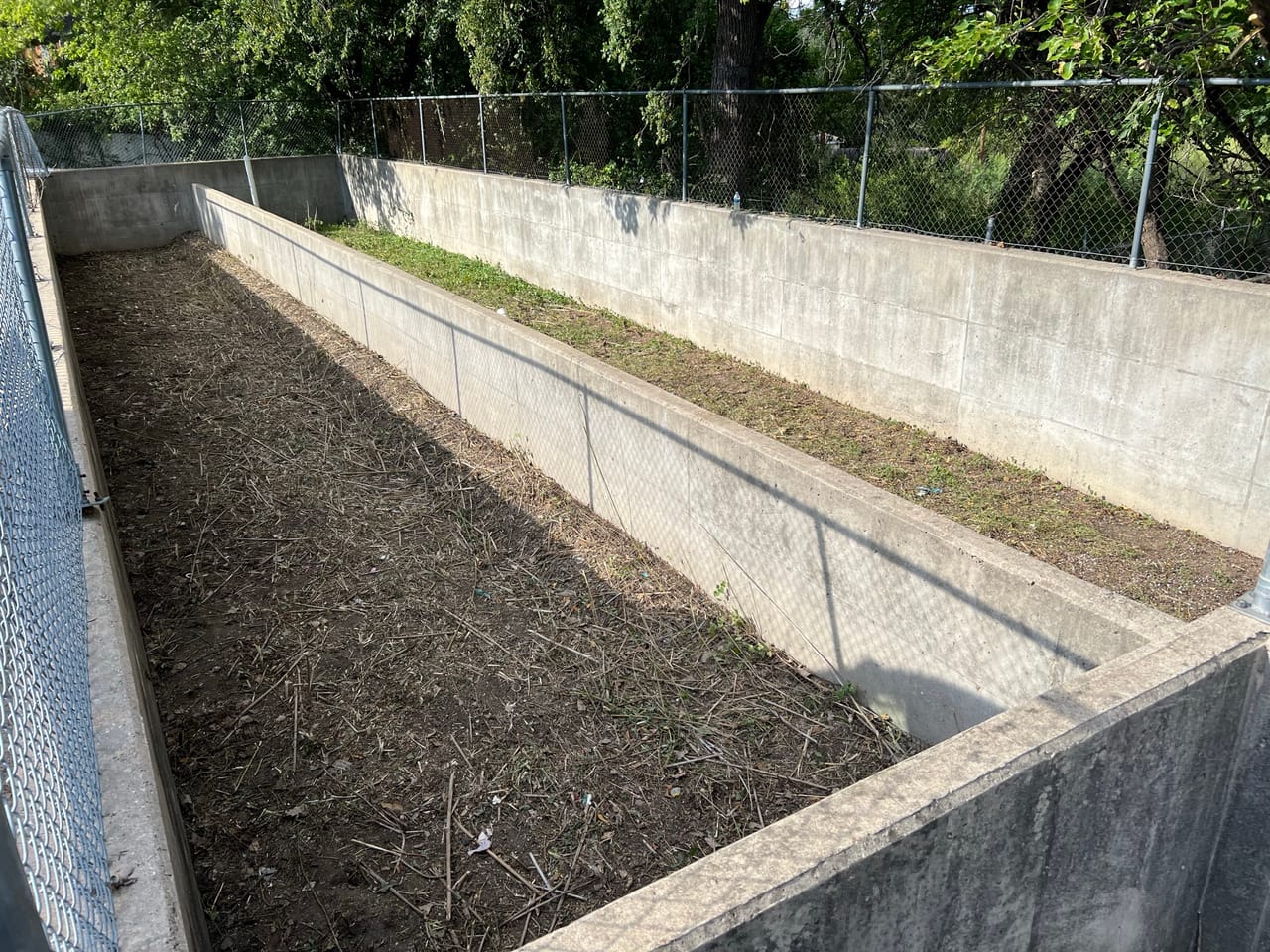Concrete walled detention basin with cleared mulched bottom in Elgin, TX