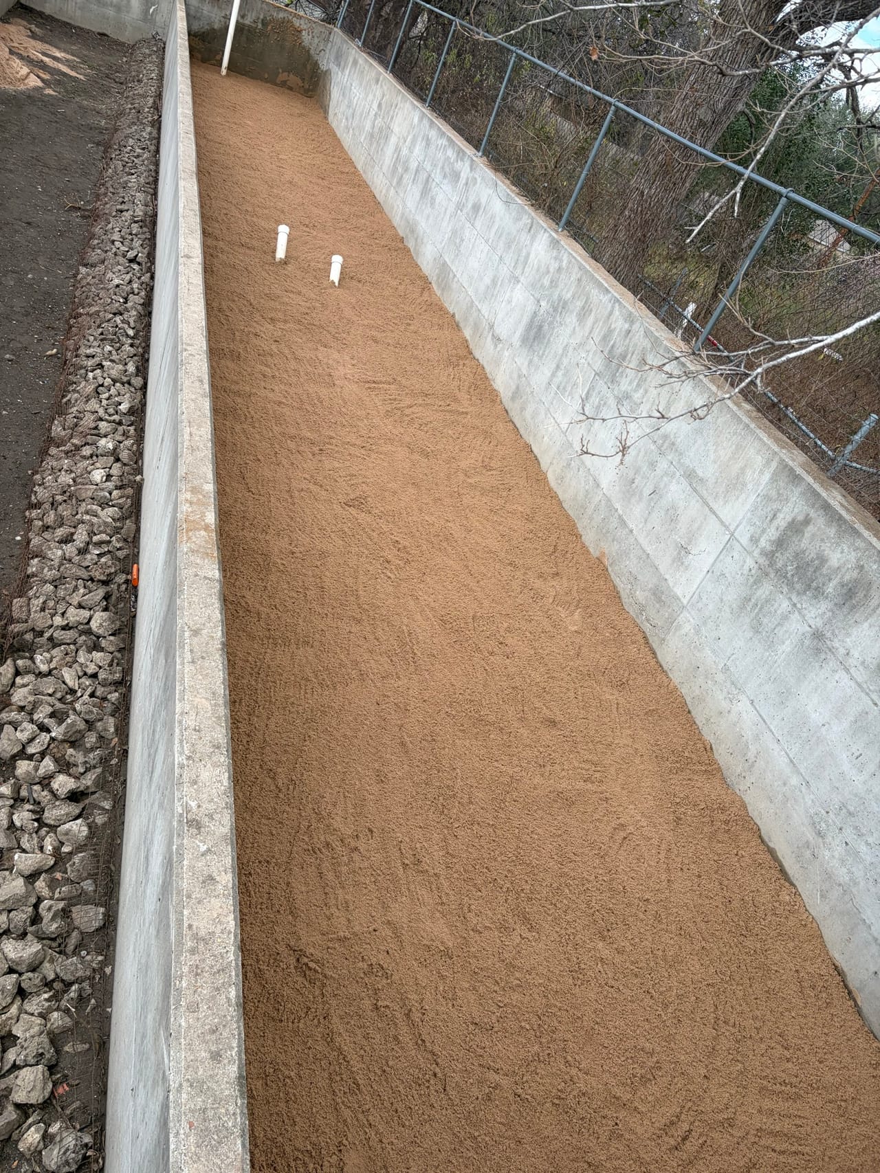 Long concrete channel with a freshly placed smooth soil slope in San Antonio, TX