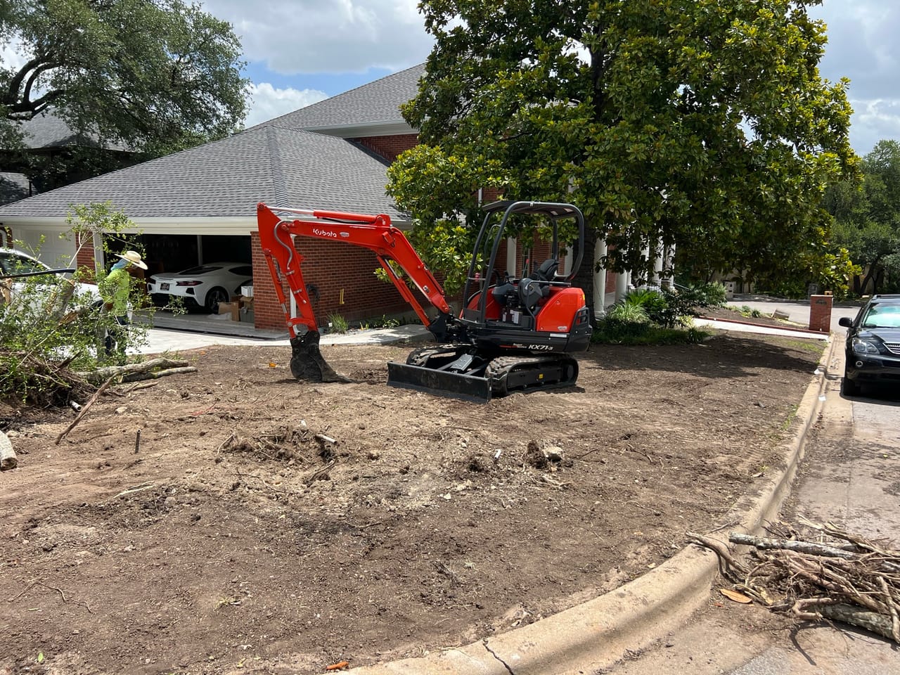 Kubota mini excavator clearing a stripped front yard after tree removal in Central Texas